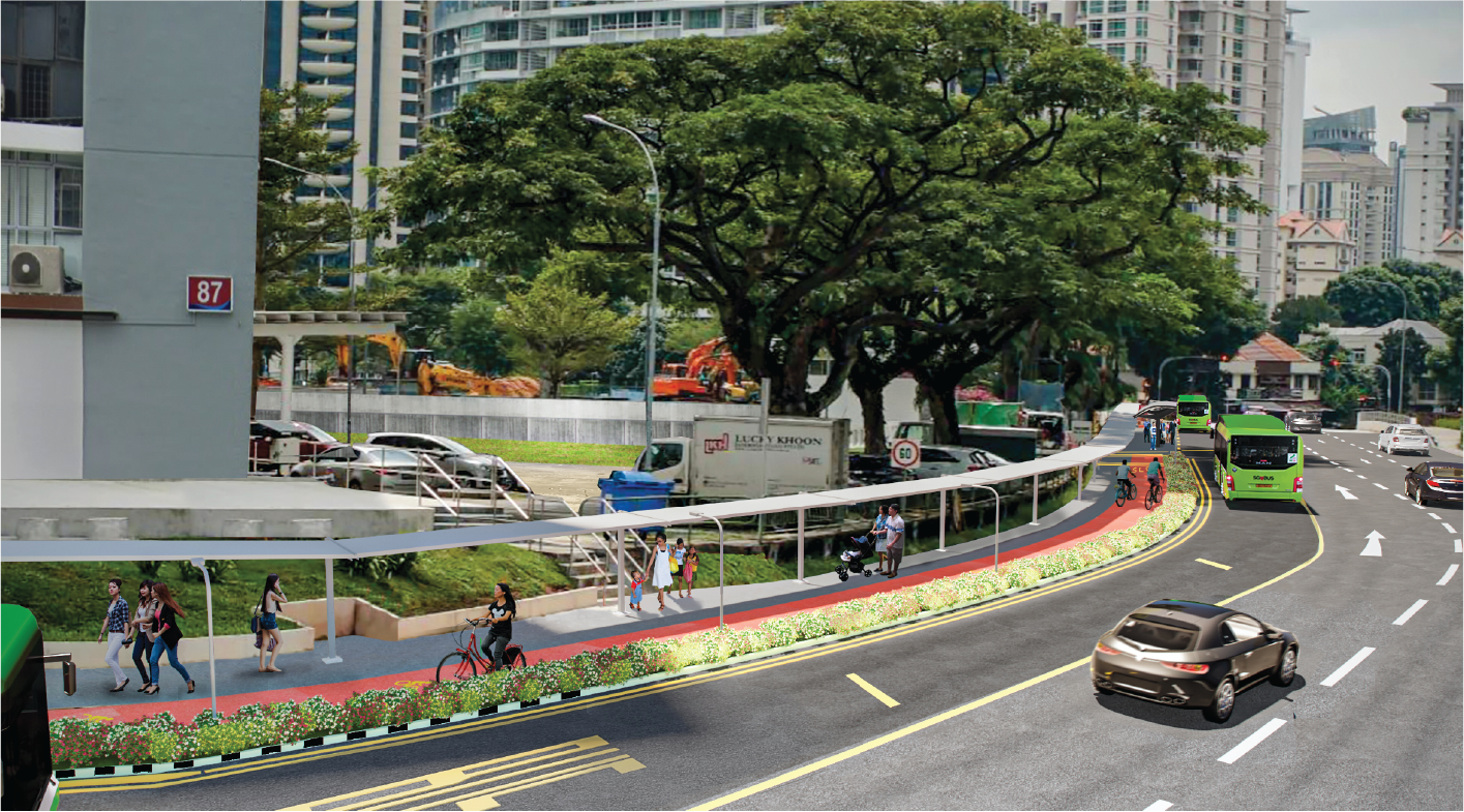 Street scene showing a walkway, a bicycle path, car and bus traffic, and apartment buildings.